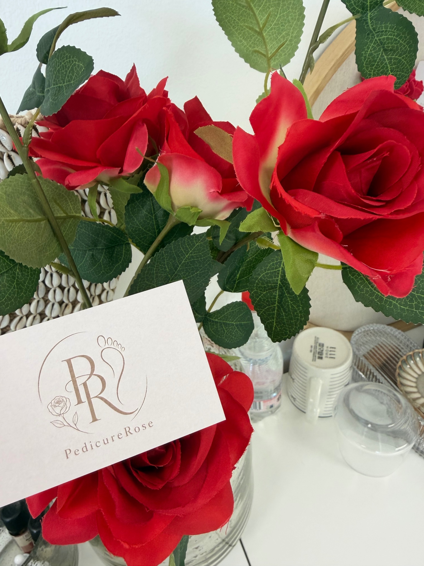 Rode rozen naast het visitekaartje van Pedicure Rose in Middelharnis